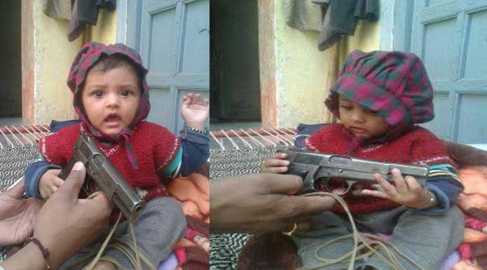 policeman gives pistol to baby